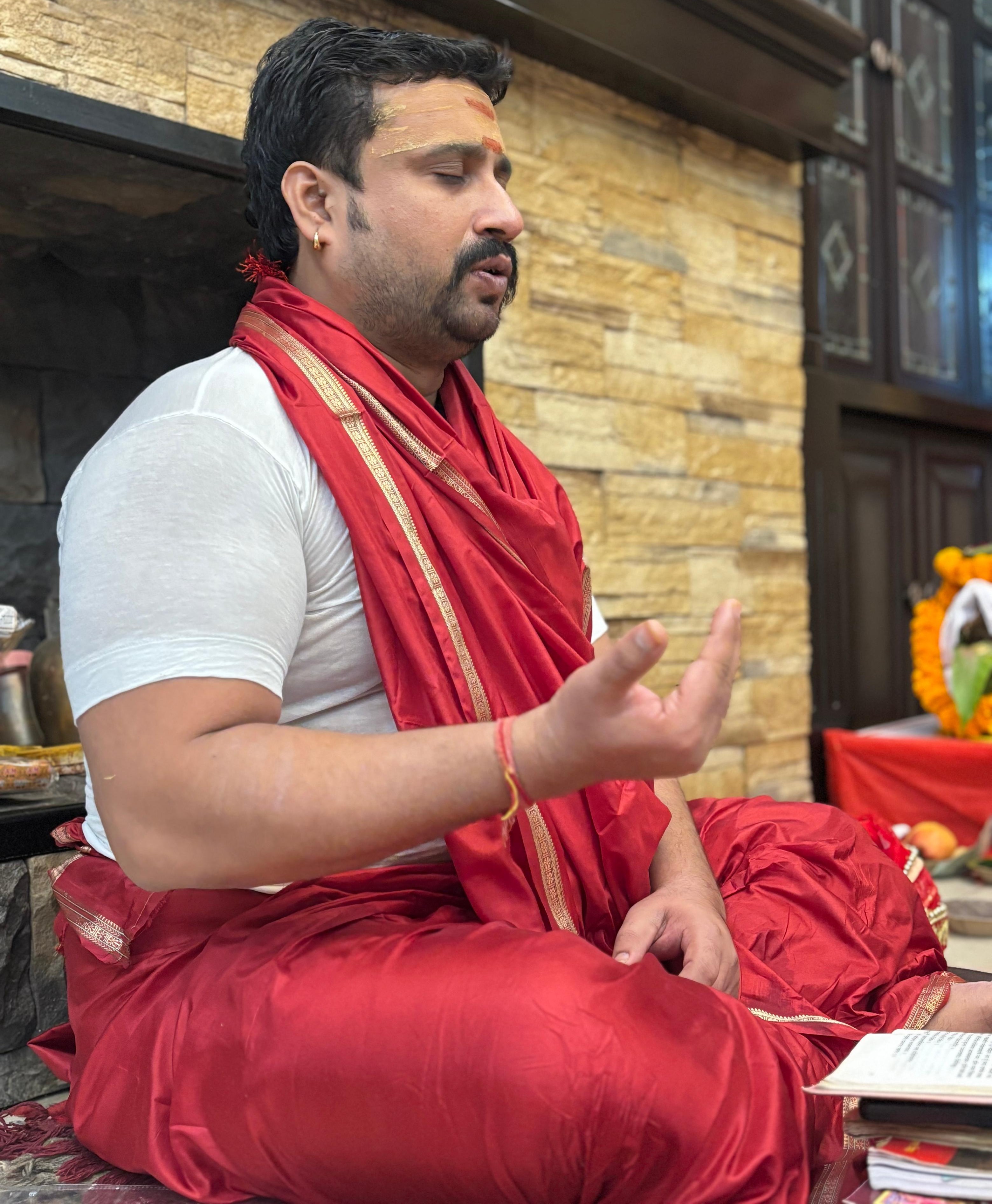 Experienced Hindu priest in traditional attire with gentle smile