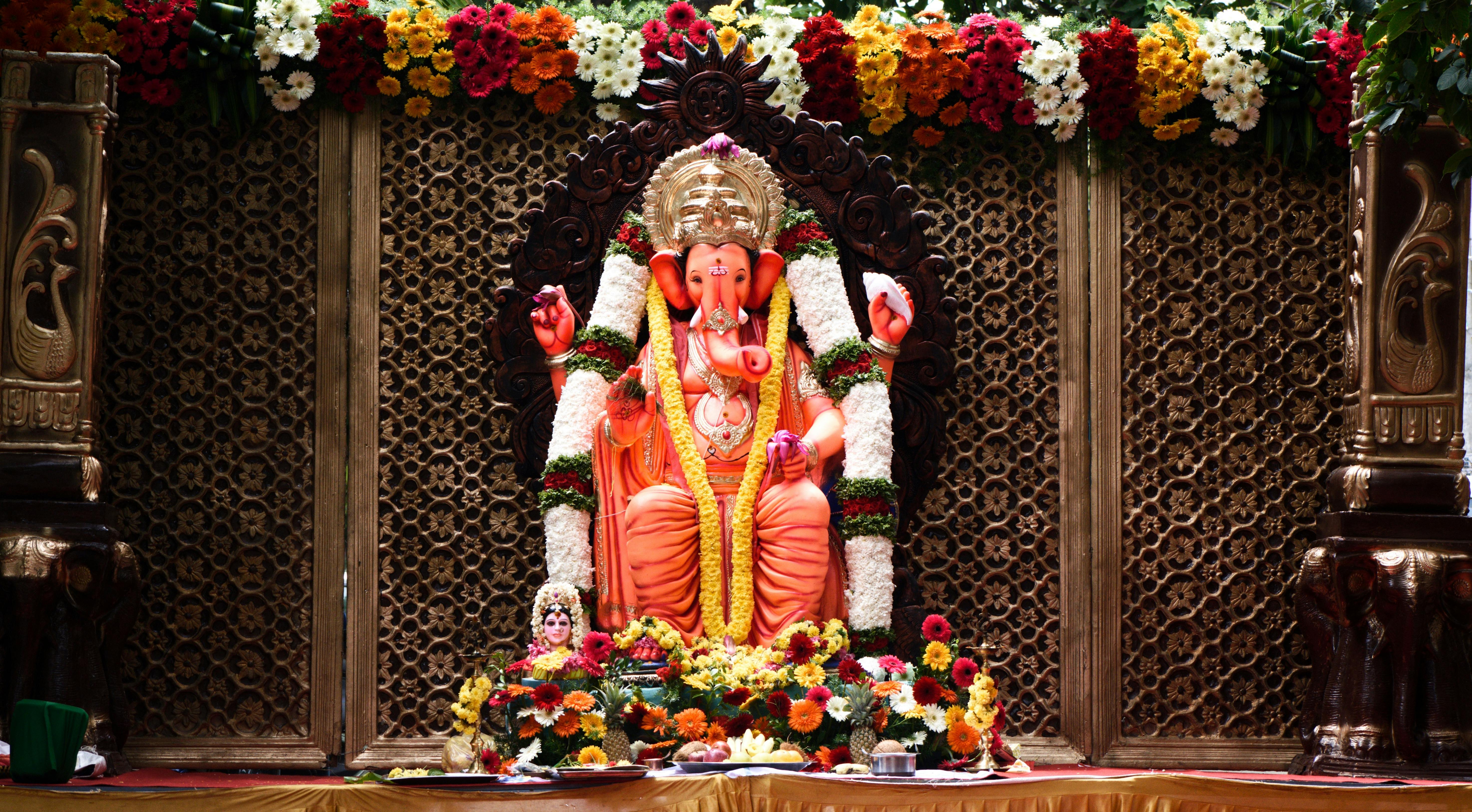Ganesh Chaturthi puja setup with idol, flowers and offerings